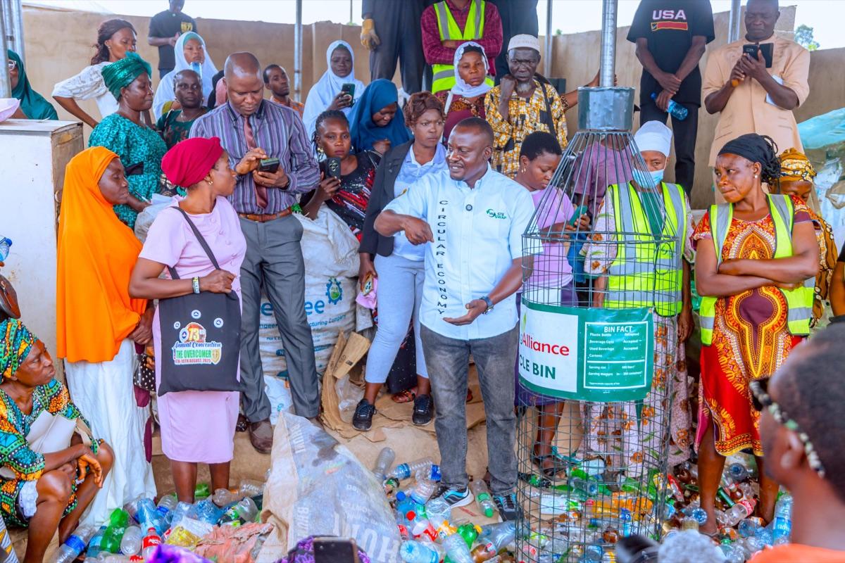 Community members gathered around a recycling bin demonstration at a waste management awareness event in Osun State, part of the circular economy programme