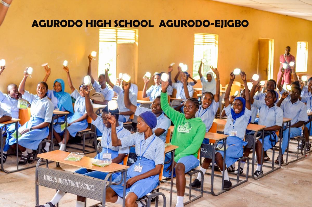 Joyful students at Agurodo High School Agurodo-Ejigbo raising lit solar lanterns high in the air after receiving them through the One Child One Lantern initiative